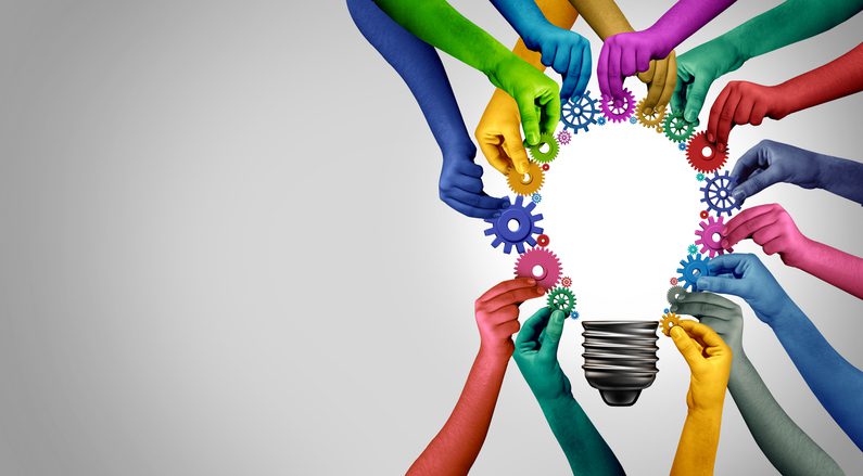 Hands of different colors assemble gears around a light bulb outline, with a gradient background from gray to white.