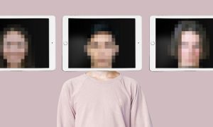 Three tablet screens displaying pixelated images positioned above a person wearing a light pink sweatshirt, set against a solid pastel background.