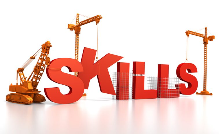 Illustration of the word “SKILLS” in large red 3D letters being constructed by three orange construction cranes and a bulldozer on a white background.